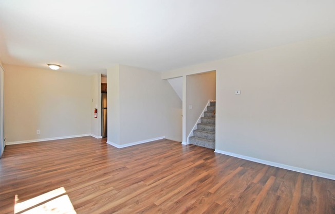 a living room with a hard wood floor and a staircase