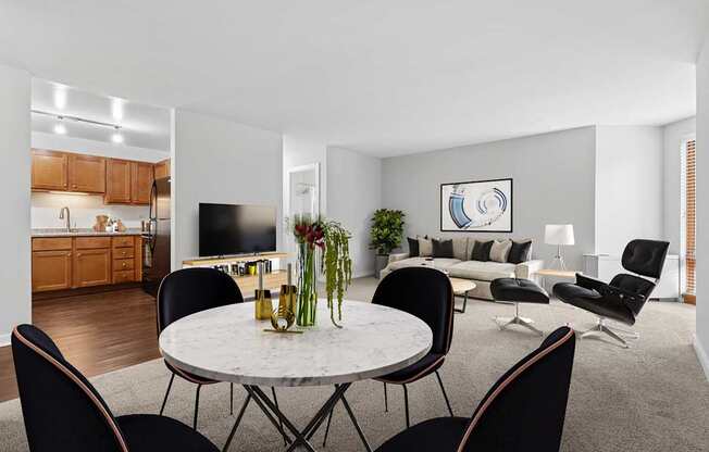 A modern living room with a dining table and chairs.