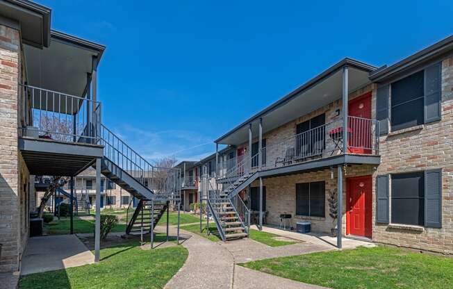 An exterior photo of a two-story apartment  building (Costa Mesa Apartments) with stairs