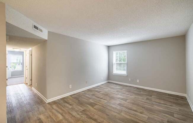 A room with wooden flooring and a window.