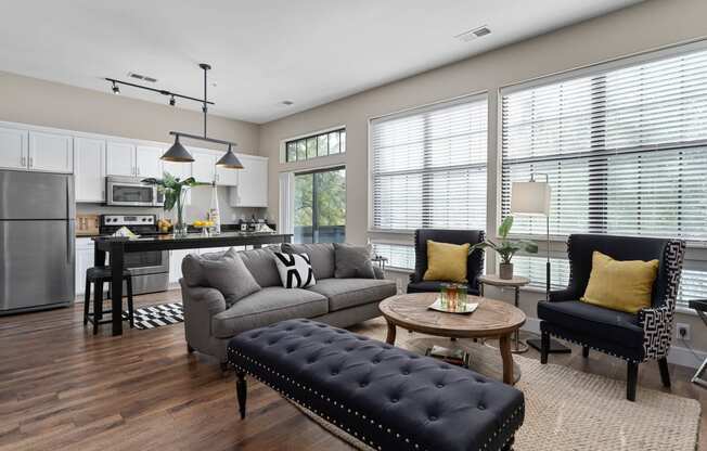 an open living room and kitchen with a couch and chairs at Hayden Lofts, Dublin, OH, 43016