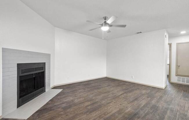 A room with a fireplace and a ceiling fan.