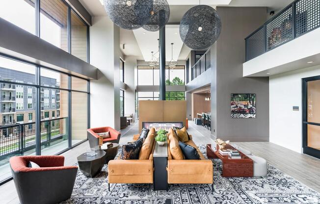 Expansive lounge with floor-to-ceiling windows, designer seating, and a fireplace centerpiece—an inviting retreat at Modera LoSo.