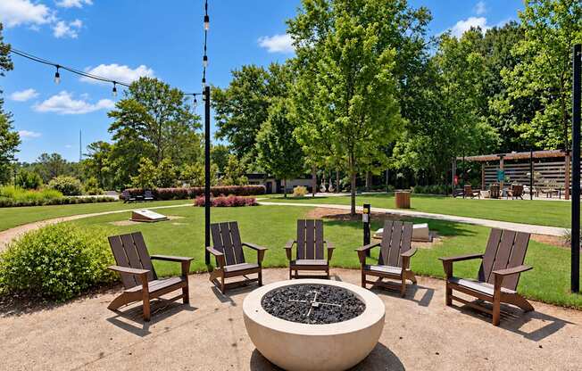 Outdoor fire pit with Adirondack chairs and overhead string lights at Icon Avondale Apartments in Decatur, GA.