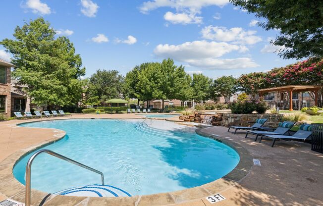 View of Resort Style Pool, Showing Sundeck, Lounge Chairs, and Seating with Umbrellas at Enclave on Golden Triangle Apartments