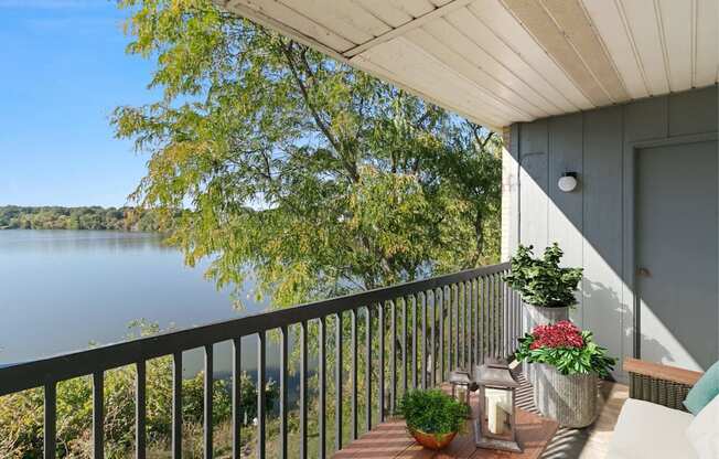 A balcony with a view of a lake and trees.