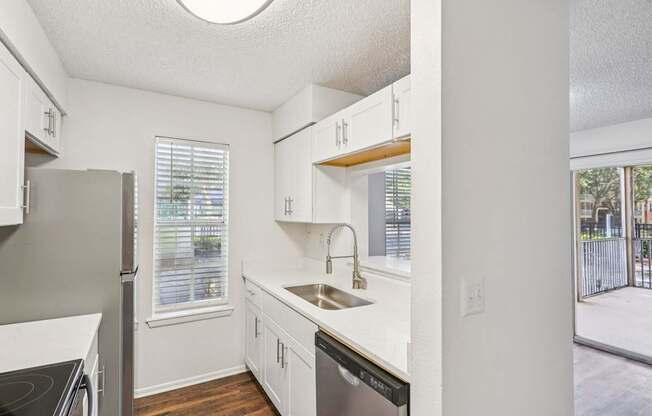 A kitchen with white cabinets and a black stove top oven.