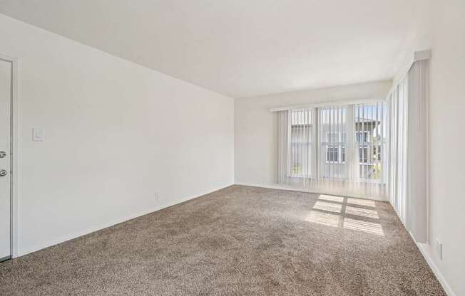 A room with a carpeted floor and a door.