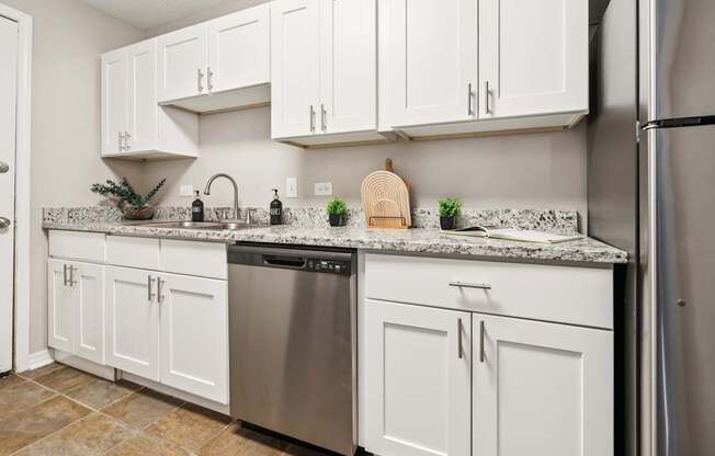 A kitchen with white cabinets and a granite countertop.