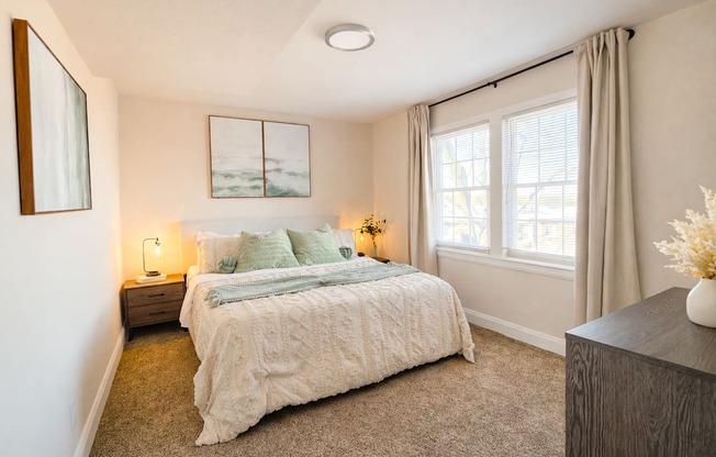 A bedroom with a large bed and a painting on the wall.