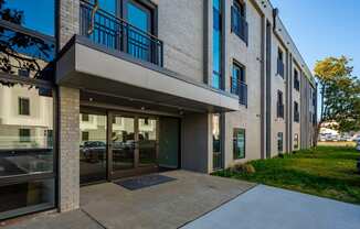 the entrance to a building with a sidewalk and glass doors