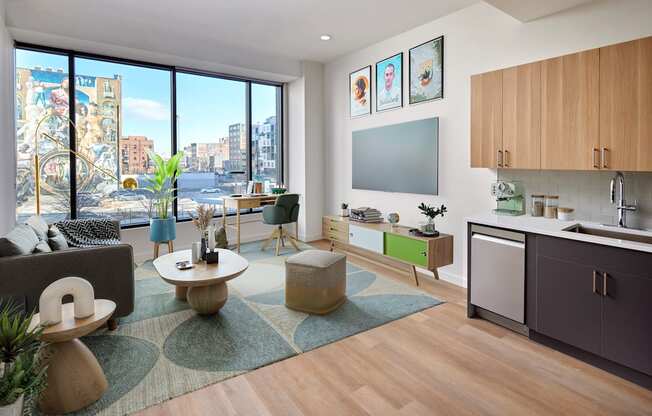 A living room with a couch, a coffee table, and a large window overlooking a city.