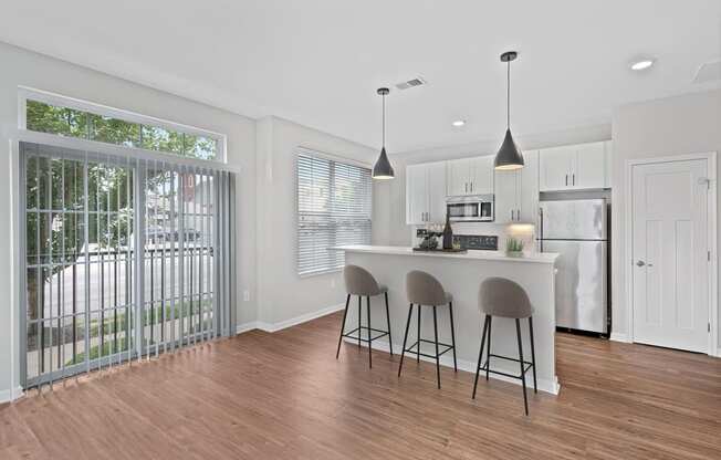 a kitchen with a bar and a sliding glass door