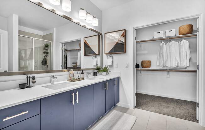 a blue and white bathroom with two sinks and a mirror