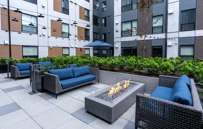 A patio with a fire pit and seating area.