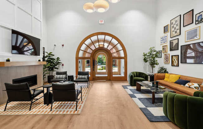 A living room with a wooden floor and a large arched doorway.