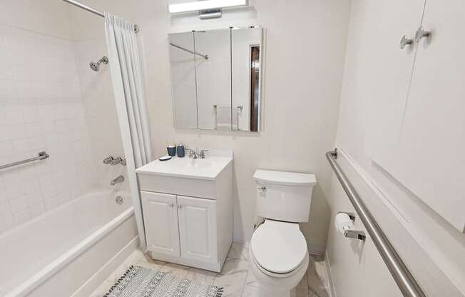 Model Bathroom with White Cabinets, Tile Flooring & Shower/Tub at Walnut Creek Apartments located in Walnut Creek, CA.