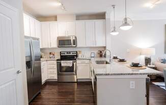 A kitchen with white cabinets and a granite countertop.