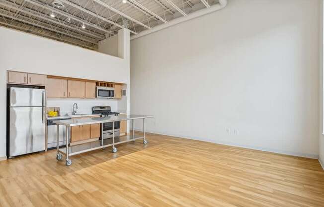 A kitchen area with a refrigerator, microwave, and a table with chairs.