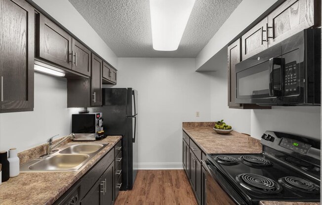 a kitchen with black appliances and counter tops and