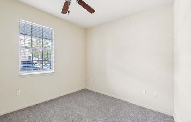 A room with a ceiling fan and a window.