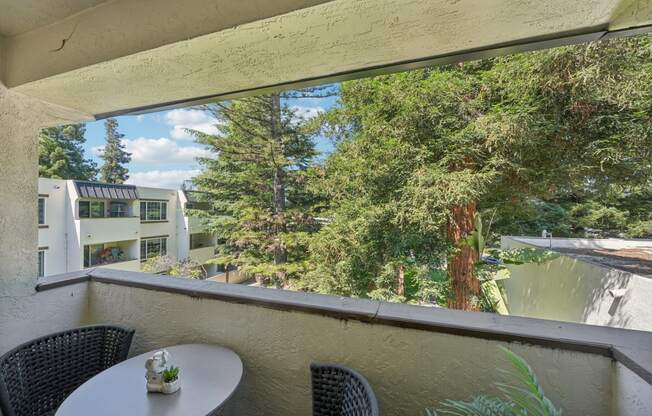 a balcony with a table and chairs and a large window