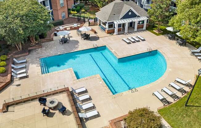 an overhead view of a swimming pool and patio with chairs