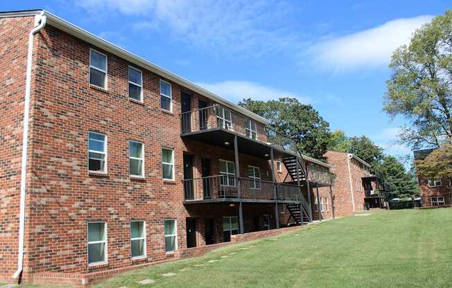 A red brick building with a balcony and stairs.