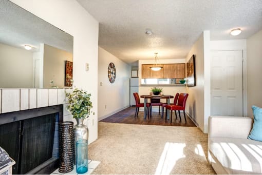 a living room with a fireplace and a dining room table