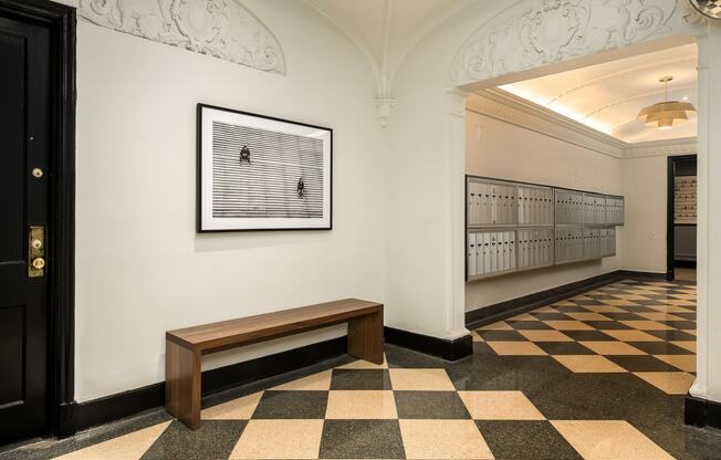 a view of a hallway with a bench and a picture on the wall