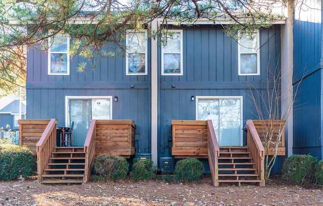 A blue house with wooden stairs leading to the front door.