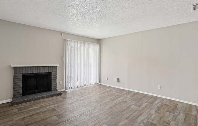 A5 living room with a fireplace and vinyl wood flooring at Windridge on the Parkway apartments in Dallas, TX