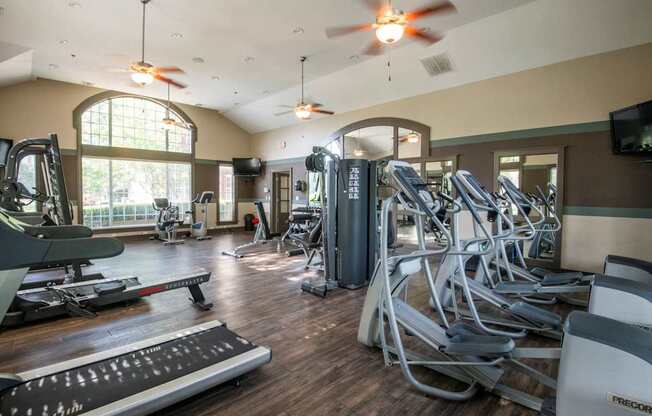 A gym with treadmills, elliptical machines, and other exercise equipment.