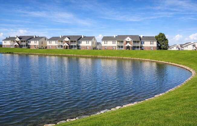 A row of houses with a pond in front.