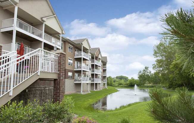 a building overlooking a pond with a fountain