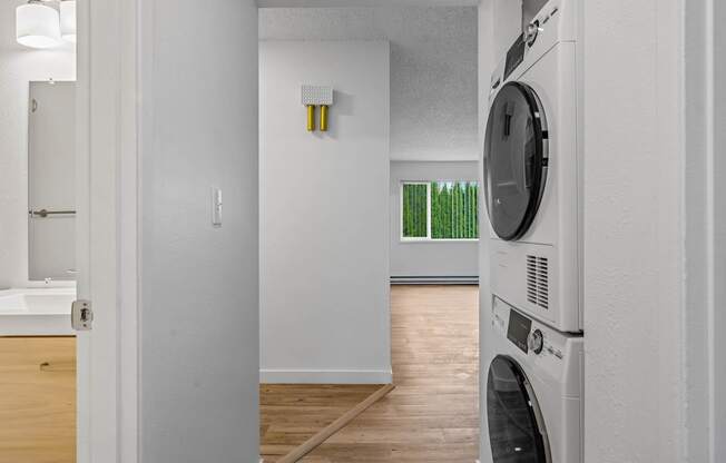 a washer and dryer in a room with a bathroom in the background