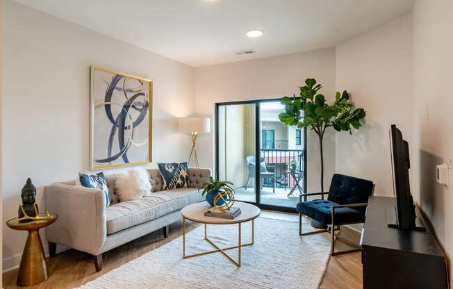 a living room with a couch coffee table and chair and a sliding glass door to a balcony  at Century West Pryor, Missouri, 64081
