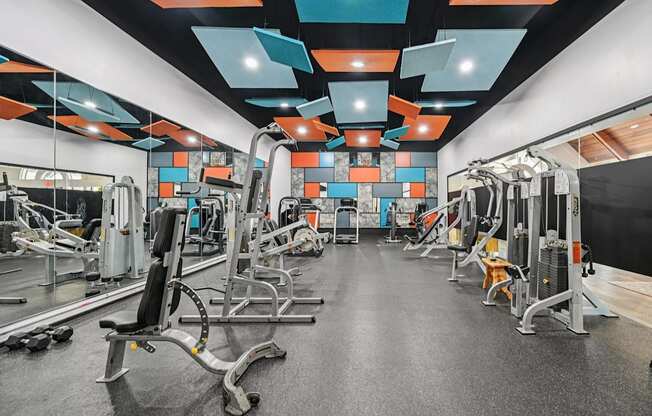 A gym with a variety of equipment including weights and machines.