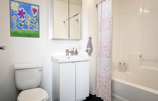 A white toilet sits next to a white sink in a bathroom.
