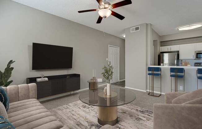 A modern living room with a glass coffee table and a flat screen TV mounted on the wall.