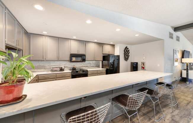Clubhouse Kitchen with Bar Seating, White Counter, Cabinets and Refrigerator