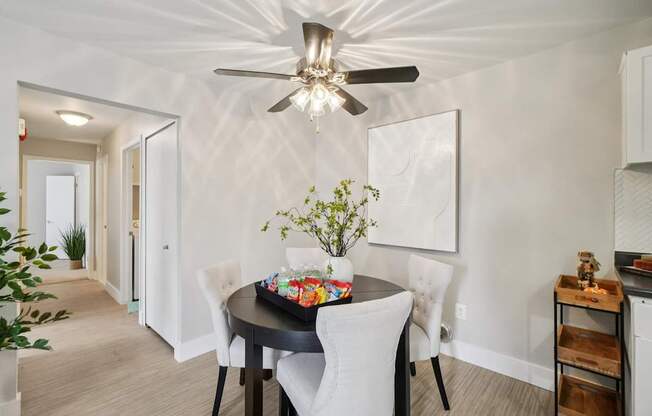 A dining room with a table set for four.