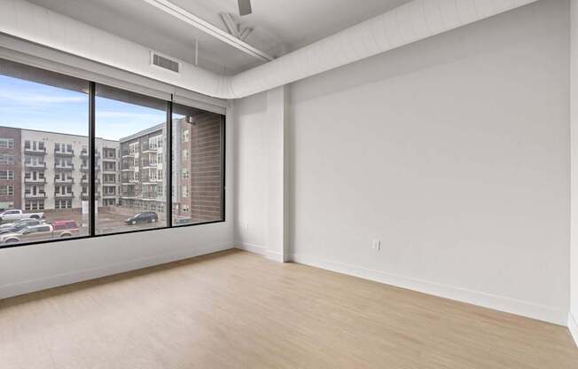 Empty room with a window overlooking a parking lot. at Brickside Heights, Millcreek, 84106