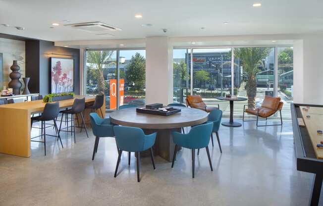 a dining room with a table and chairs in a room with large windows