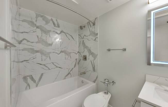 a bathroom with a toilet and a tub and a sink