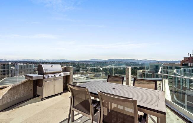 A patio with a table and chairs overlooking a cityscape.