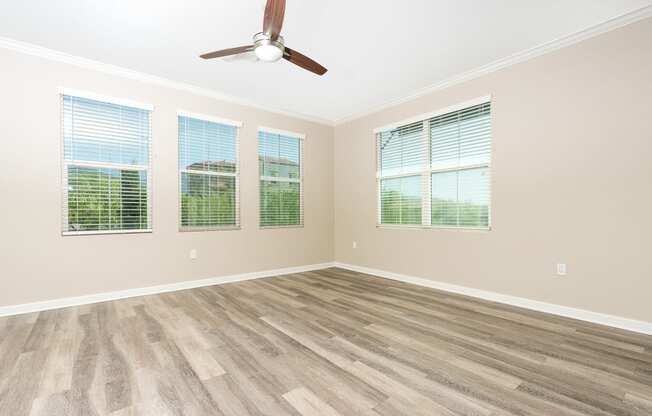 bedroom with windows and ceiling fam and wood style flooring.