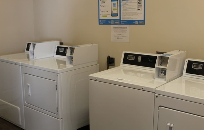 three washers and dryers in a laundry room