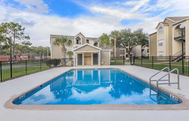A swimming pool in a residential area with houses in the background.