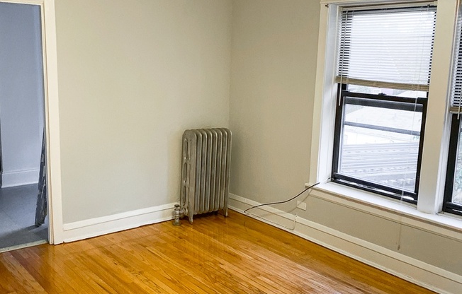 an empty room with wooden floors and a ceiling fan